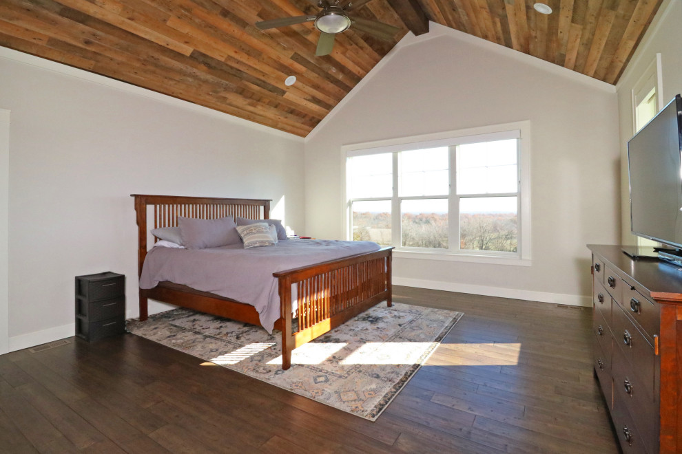 Imagen de dormitorio principal industrial grande con paredes grises, suelo de madera en tonos medios y suelo marrón