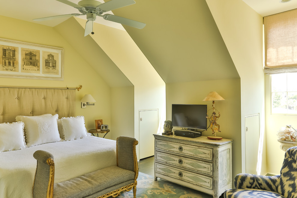 Ejemplo de dormitorio principal tradicional renovado de tamaño medio sin chimenea con paredes amarillas, suelo de madera oscura y suelo marrón