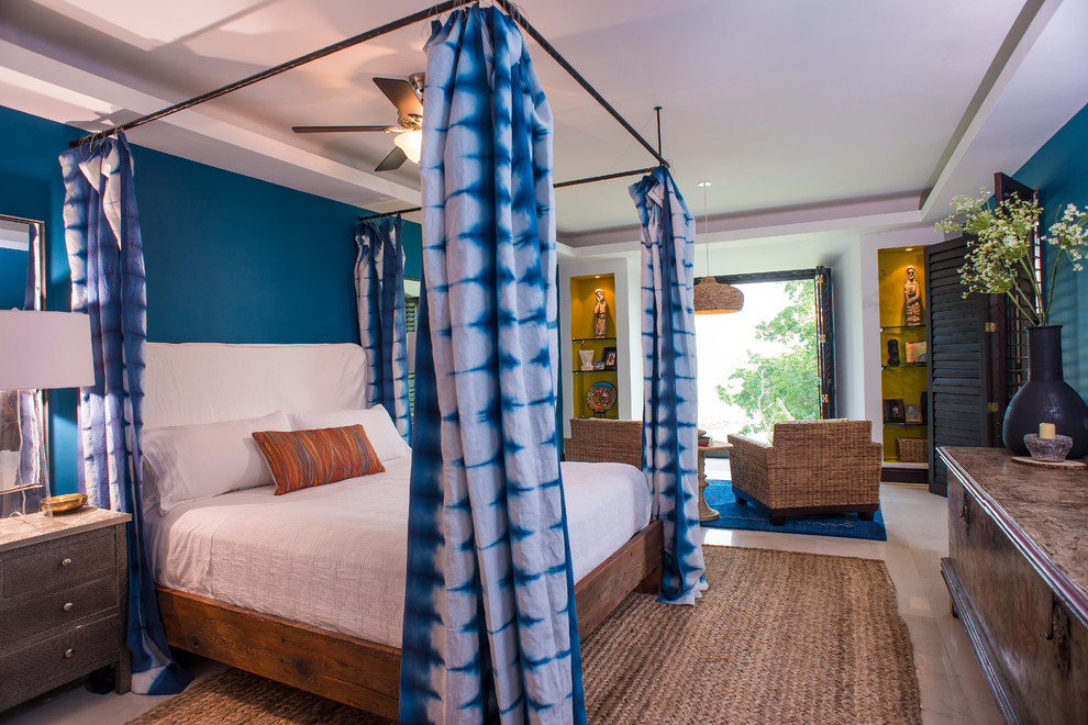 広いトロピカルスタイルのおしゃれな主寝室 (青い壁、大理石の床)
