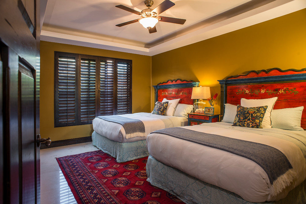 Esempio di una camera degli ospiti tropicale di medie dimensioni con pareti gialle e pavimento in marmo
