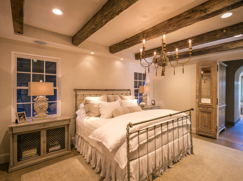 Medium sized country master bedroom in Houston with light hardwood flooring.