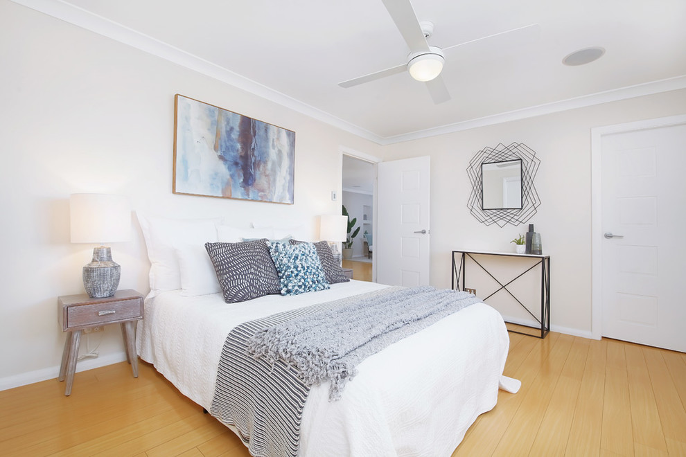 Design ideas for a large contemporary master bedroom in Sydney with white walls, laminate floors and brown floors.