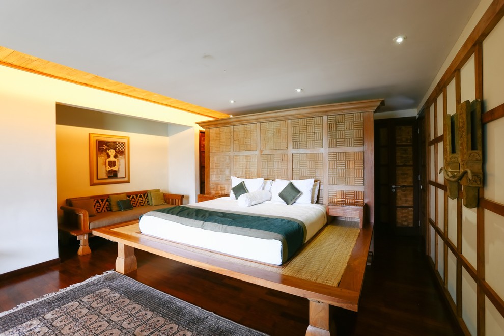 Inspiration for a tropical master dark wood floor and brown floor bedroom remodel in Singapore with white walls