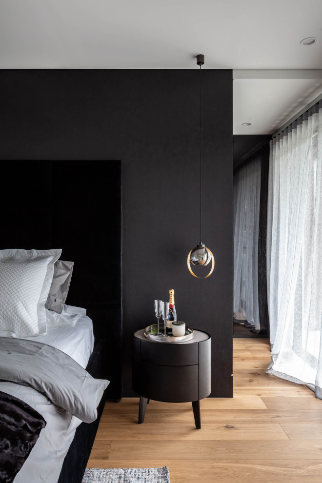Ejemplo de dormitorio gris y negro actual con paredes negras, suelo de madera en tonos medios y suelo marrón