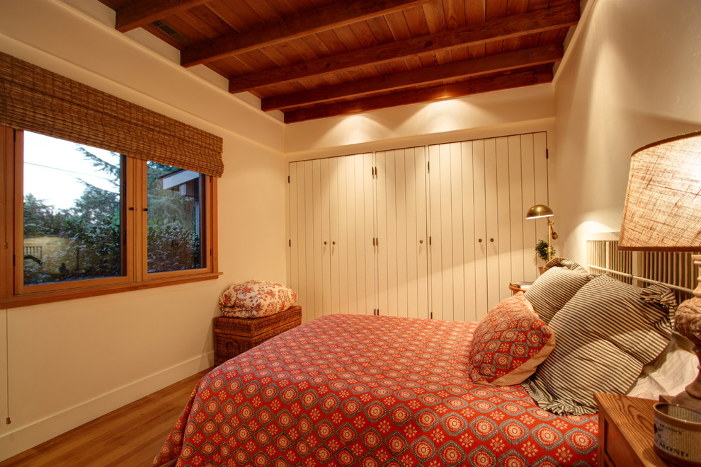 Foto de dormitorio tradicional con paredes beige y suelo de madera en tonos medios