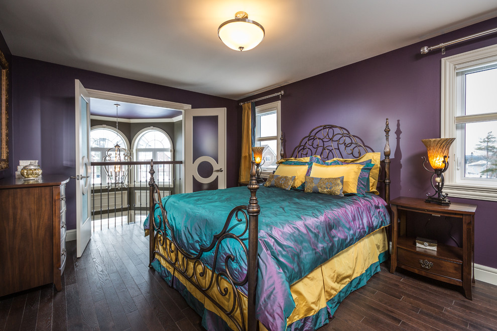 Imagen de dormitorio principal ecléctico de tamaño medio sin chimenea con paredes púrpuras y suelo de madera oscura