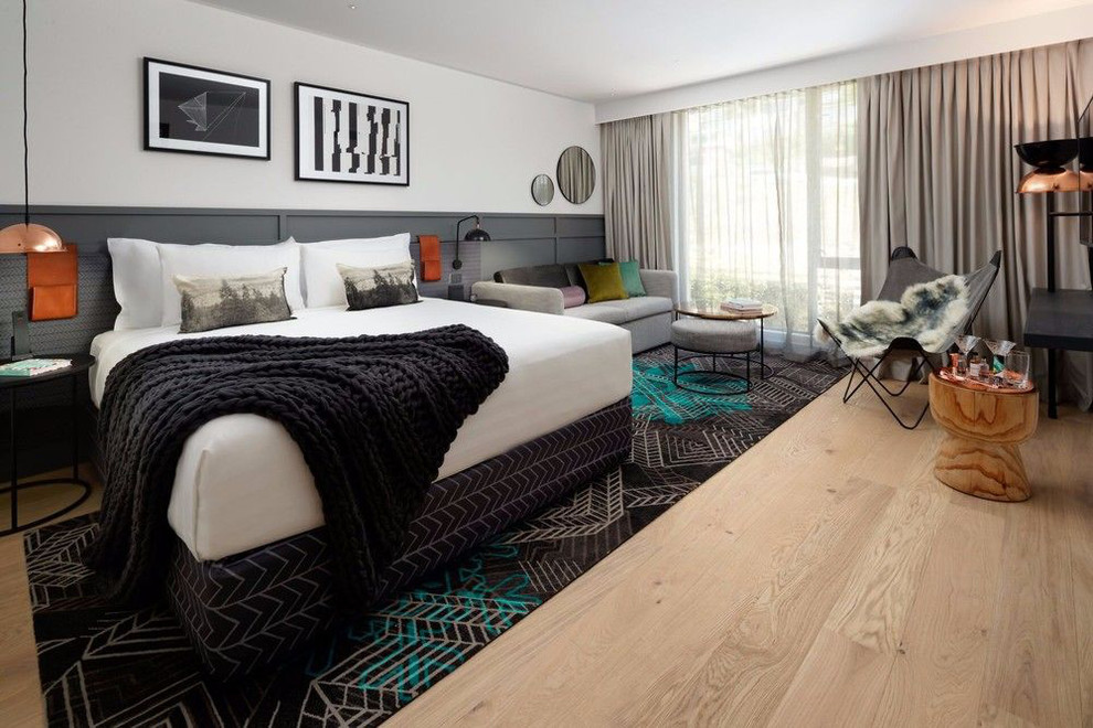Ejemplo de habitación de invitados moderna grande con suelo de madera clara, suelo blanco y paredes blancas