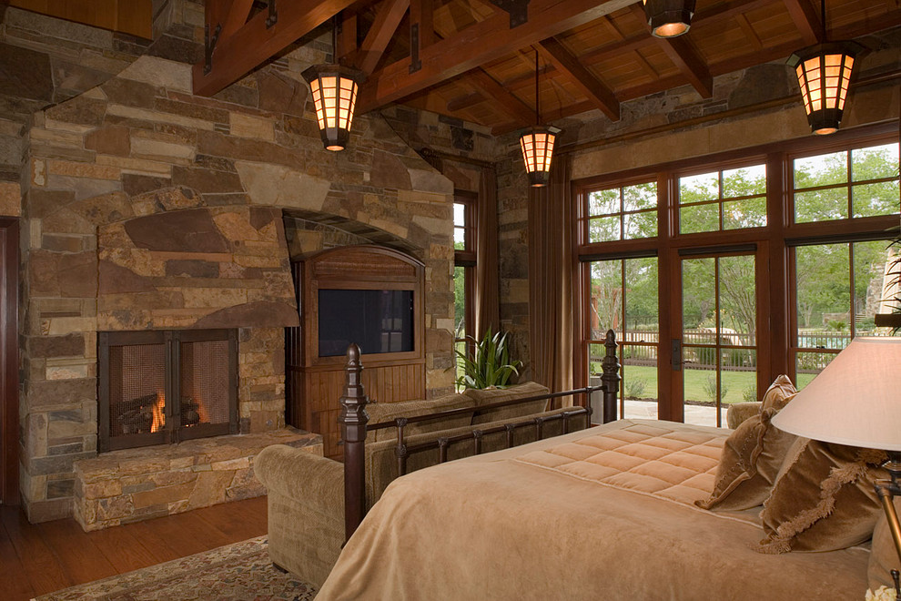 Klassisches Schlafzimmer mit braunem Holzboden, Kamin und Kaminumrandung aus Stein in Seattle