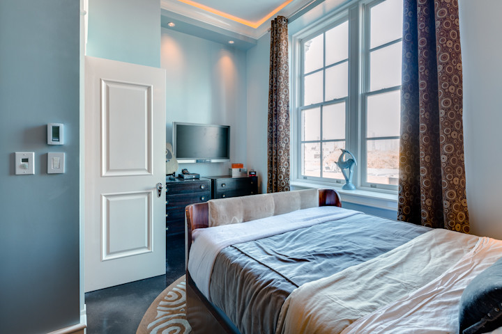 Kleines Klassisches Schlafzimmer mit blauer Wandfarbe, Betonboden, schwarzem Boden und eingelassener Decke in Philadelphia