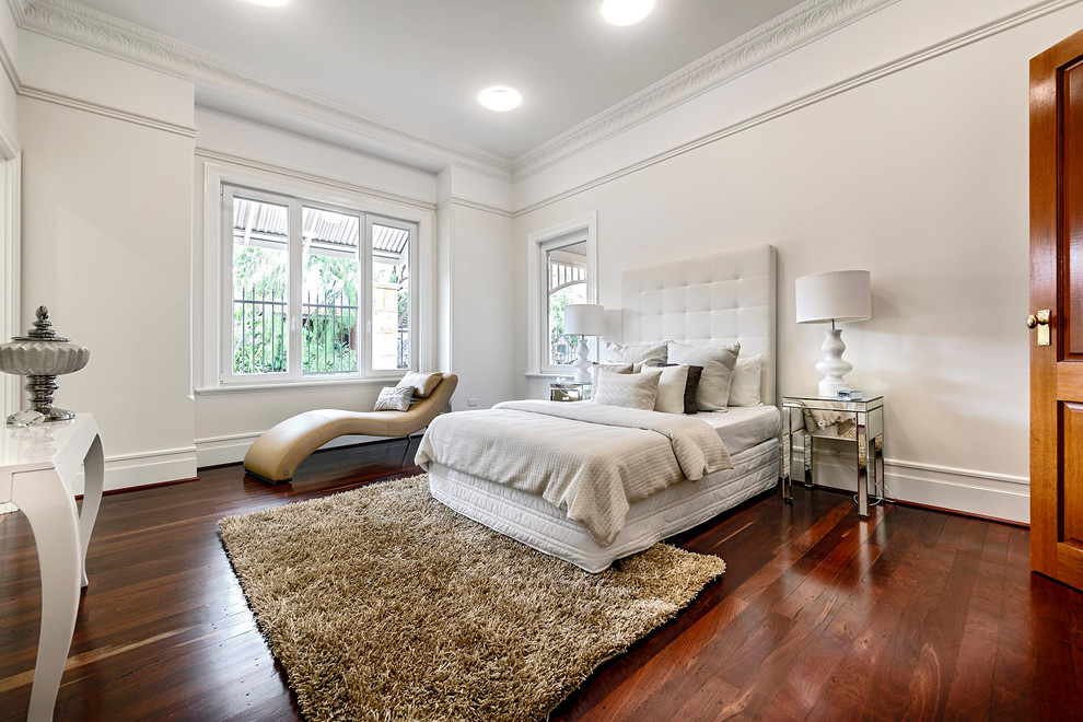Immagine di una camera da letto classica con pareti bianche e pavimento marrone