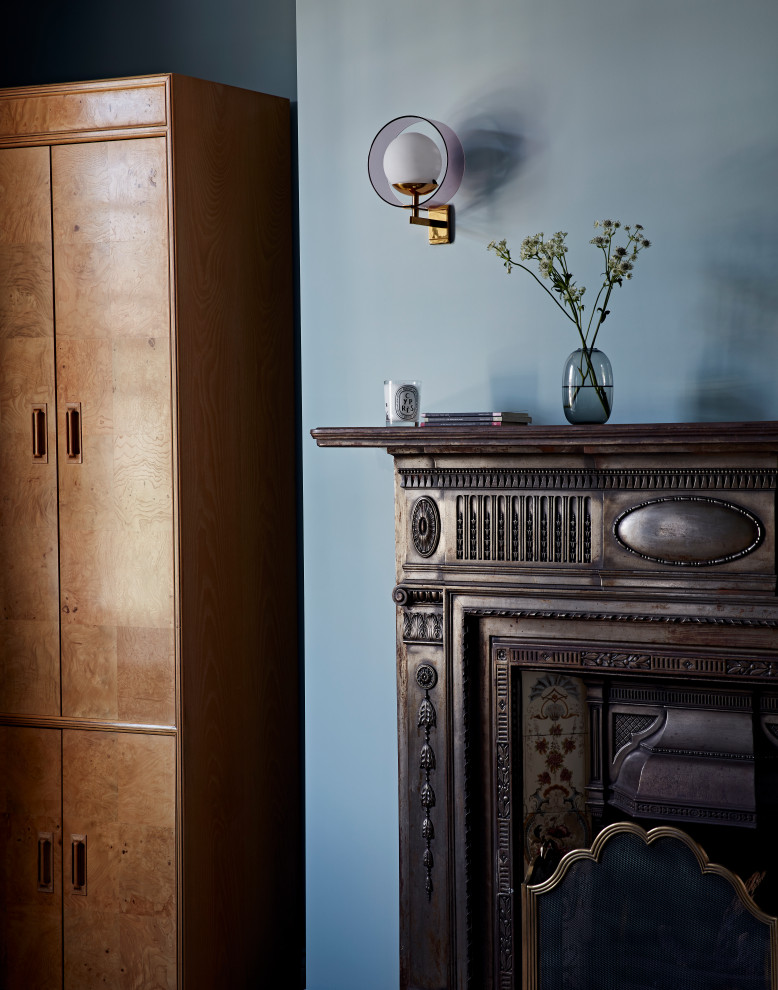Ispirazione per una camera matrimoniale minimal con pareti blu, camino classico e cornice del camino in metallo