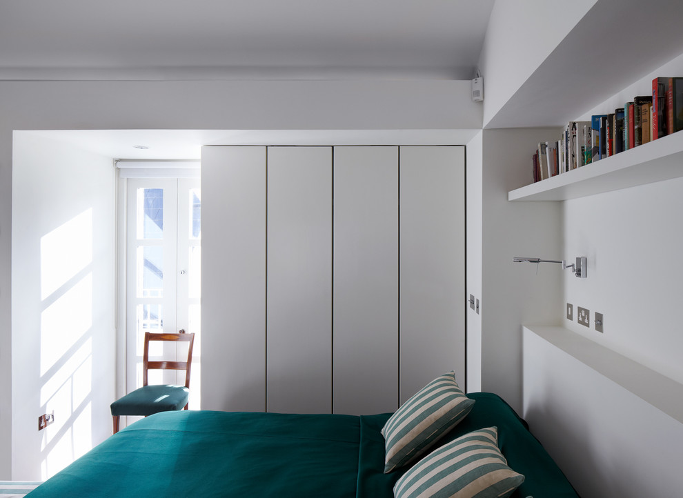 Aménagement d'une petite chambre mansardée ou avec mezzanine contemporaine avec un mur blanc, parquet foncé et aucune cheminée.