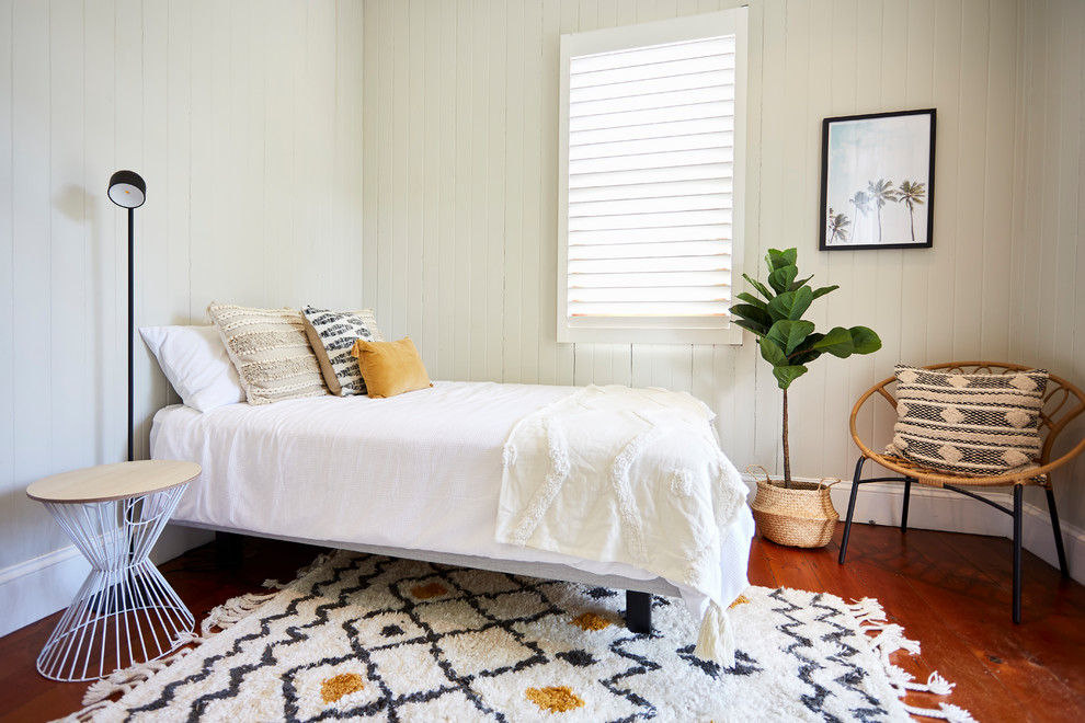 Immagine di una grande camera degli ospiti stile marinaro con pareti bianche, pavimento in legno massello medio e pavimento marrone