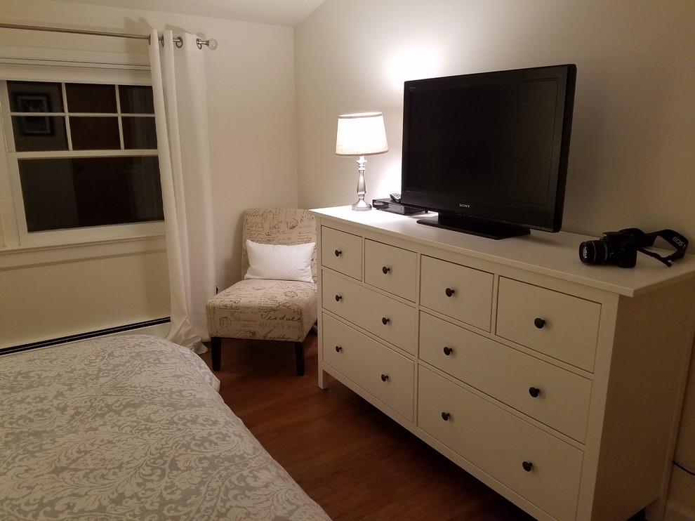 Kleines Stilmix Gästezimmer mit weißer Wandfarbe und braunem Holzboden in New York