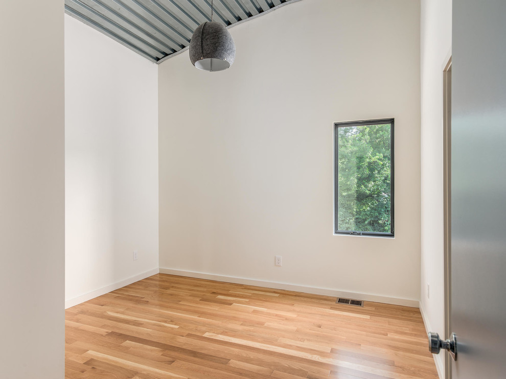 Example of a mid-sized urban guest light wood floor bedroom design in Nashville with white walls