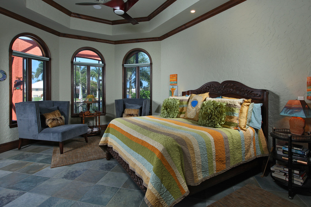 This is an example of a mediterranean master bedroom in Miami with blue walls, ceramic flooring and no fireplace.