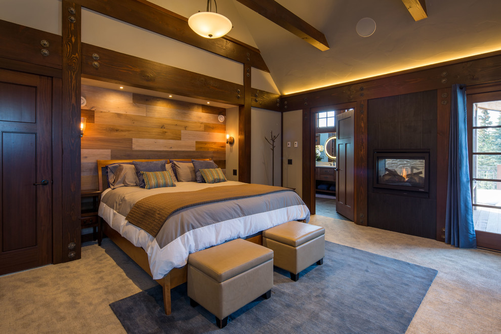 Foto de dormitorio principal de estilo americano grande con paredes grises, moqueta, chimenea de doble cara, marco de chimenea de baldosas y/o azulejos y suelo gris