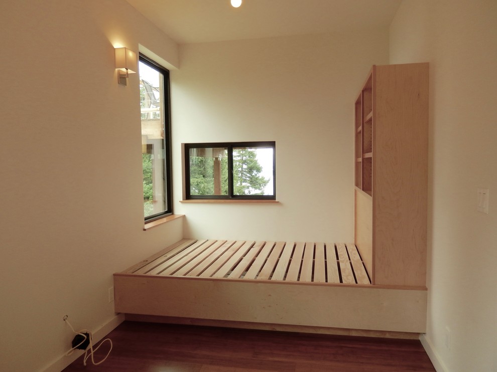 Diseño de habitación de invitados actual de tamaño medio con paredes blancas y suelo de bambú