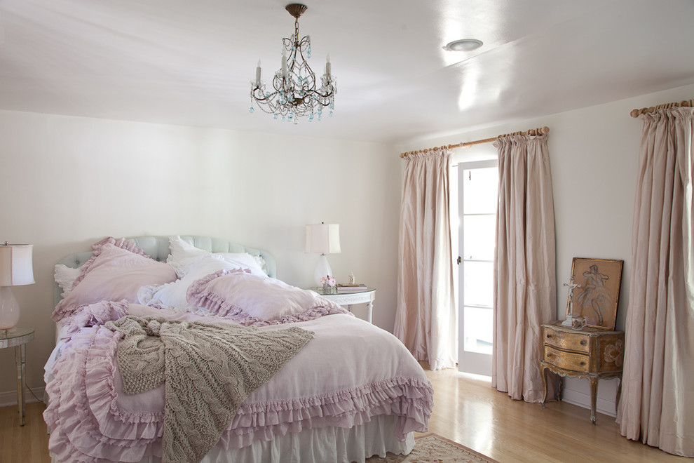 Modelo de dormitorio principal romántico con paredes blancas y suelo de madera clara