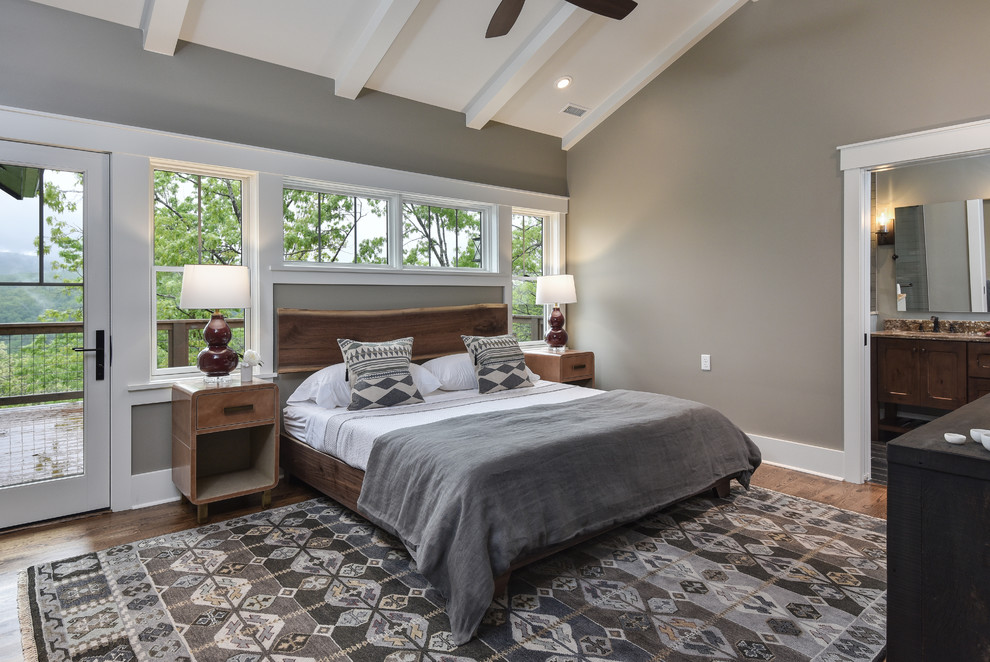 Rustikales Schlafzimmer mit grauer Wandfarbe, dunklem Holzboden und braunem Boden in Sonstige