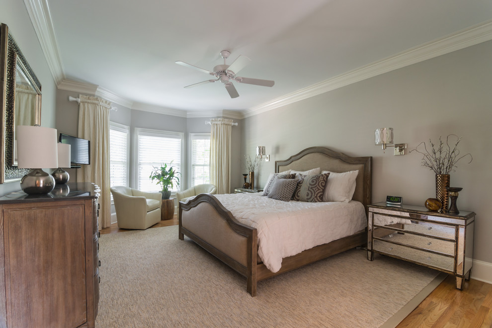 This is an example of a classic bedroom in Atlanta with grey walls and light hardwood flooring.