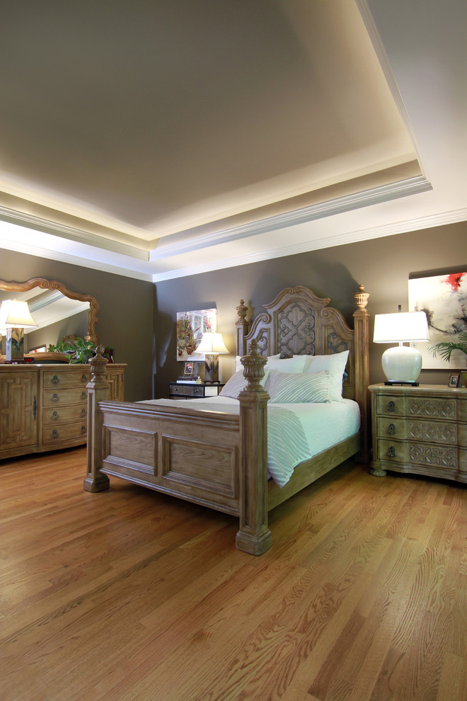 Cette image montre une chambre parentale traditionnelle de taille moyenne avec un mur gris, un sol en bois brun, une cheminée standard et un manteau de cheminée en bois.