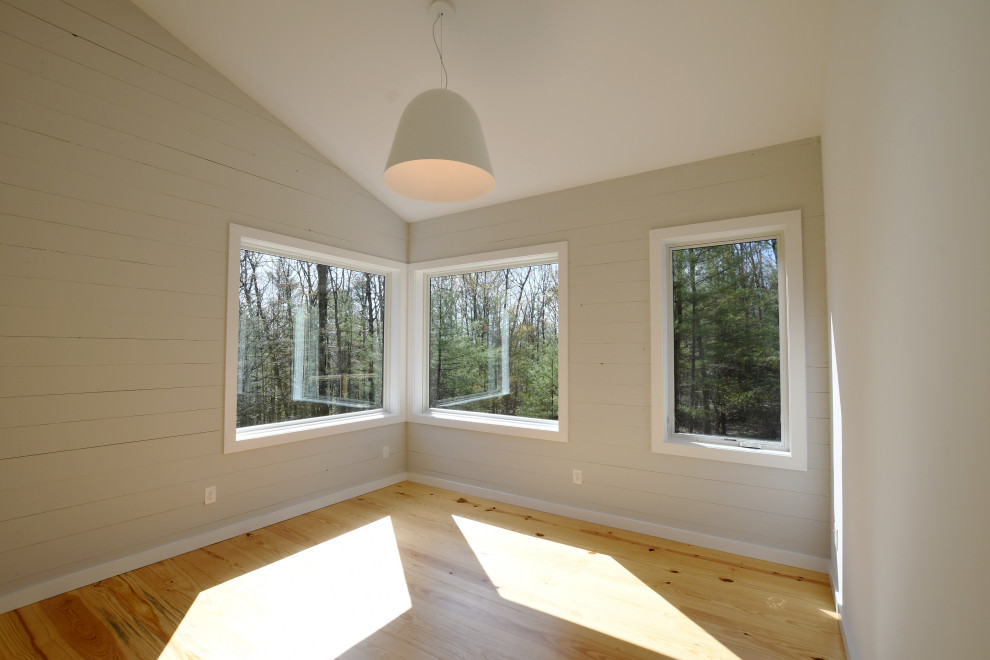 Ejemplo de dormitorio principal y abovedado retro de tamaño medio con paredes grises, suelo de madera clara, suelo marrón y machihembrado