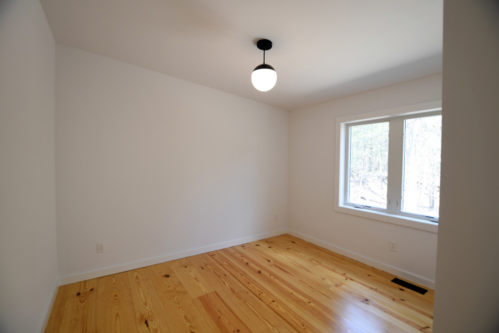 Bild på ett mellanstort retro gästrum, med vita väggar, ljust trägolv och brunt golv