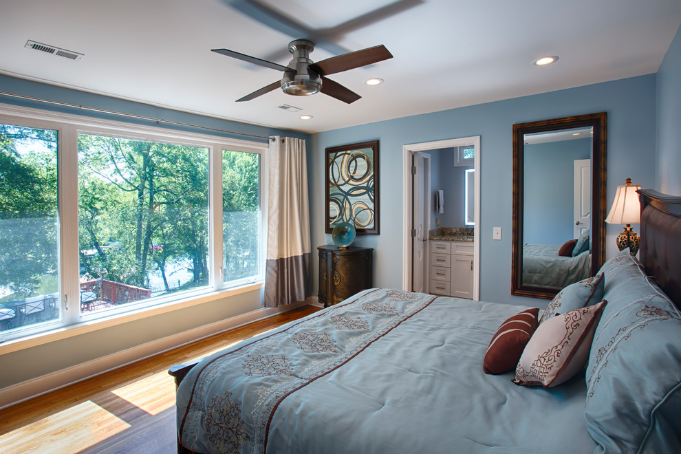 Diseño de dormitorio principal actual de tamaño medio con paredes azules, suelo de madera en tonos medios y suelo marrón