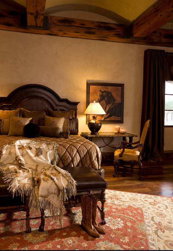 Ejemplo de dormitorio principal rústico extra grande con paredes beige, suelo de madera en tonos medios, todas las chimeneas y marco de chimenea de piedra