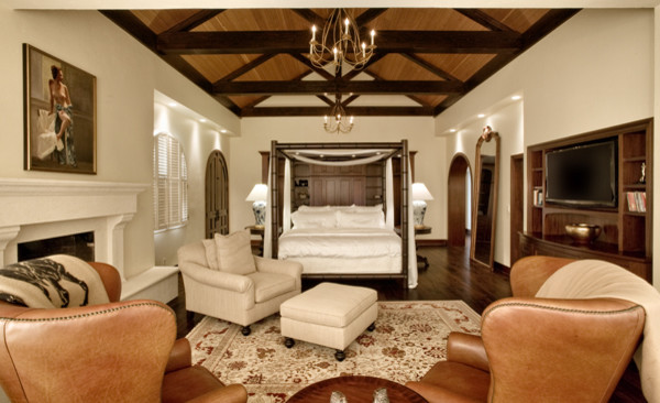 Foto de dormitorio principal clásico extra grande con paredes blancas, suelo de madera oscura, todas las chimeneas, marco de chimenea de piedra y suelo marrón