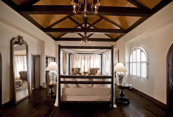 Diseño de dormitorio principal clásico extra grande con paredes blancas, suelo de madera oscura, todas las chimeneas, marco de chimenea de piedra y suelo marrón