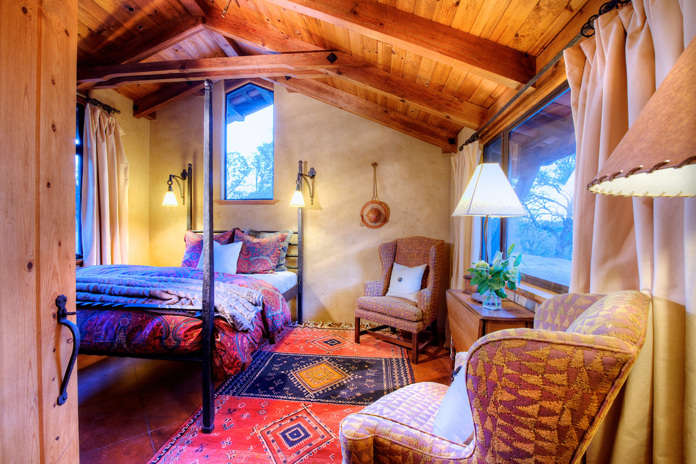 Ejemplo de habitación de invitados de estilo americano de tamaño medio con paredes amarillas y suelo de baldosas de terracota