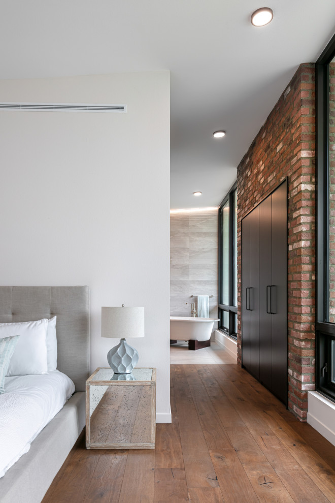 Ejemplo de dormitorio principal contemporáneo grande con paredes blancas, suelo de madera en tonos medios y suelo marrón