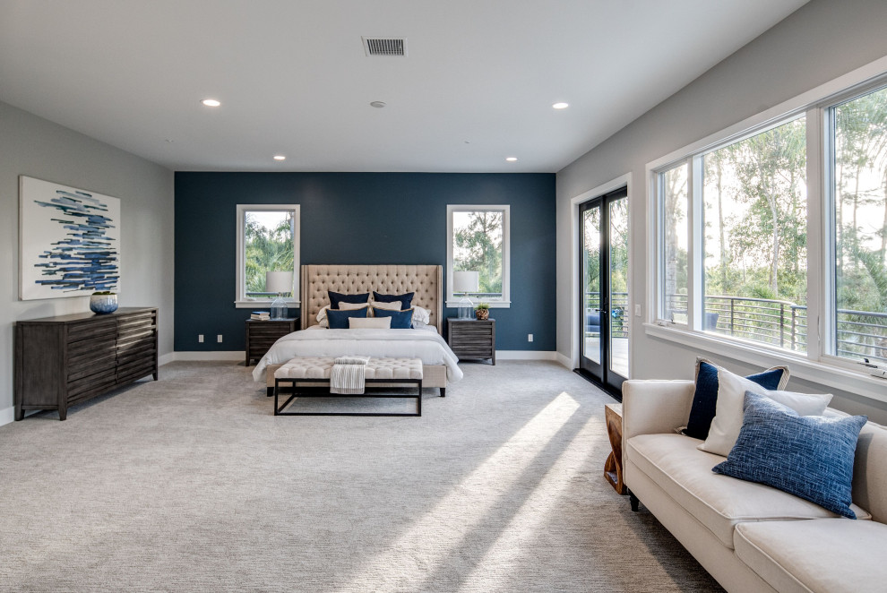 Стильный дизайн: огромная хозяйская спальня в средиземноморском стиле с синими стенами, ковровым покрытием, стандартным камином, фасадом камина из плитки и серым полом - последний тренд