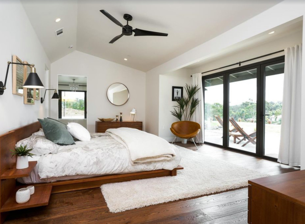Modernes Hauptschlafzimmer mit weißer Wandfarbe, braunem Holzboden, braunem Boden und gewölbter Decke in San Diego