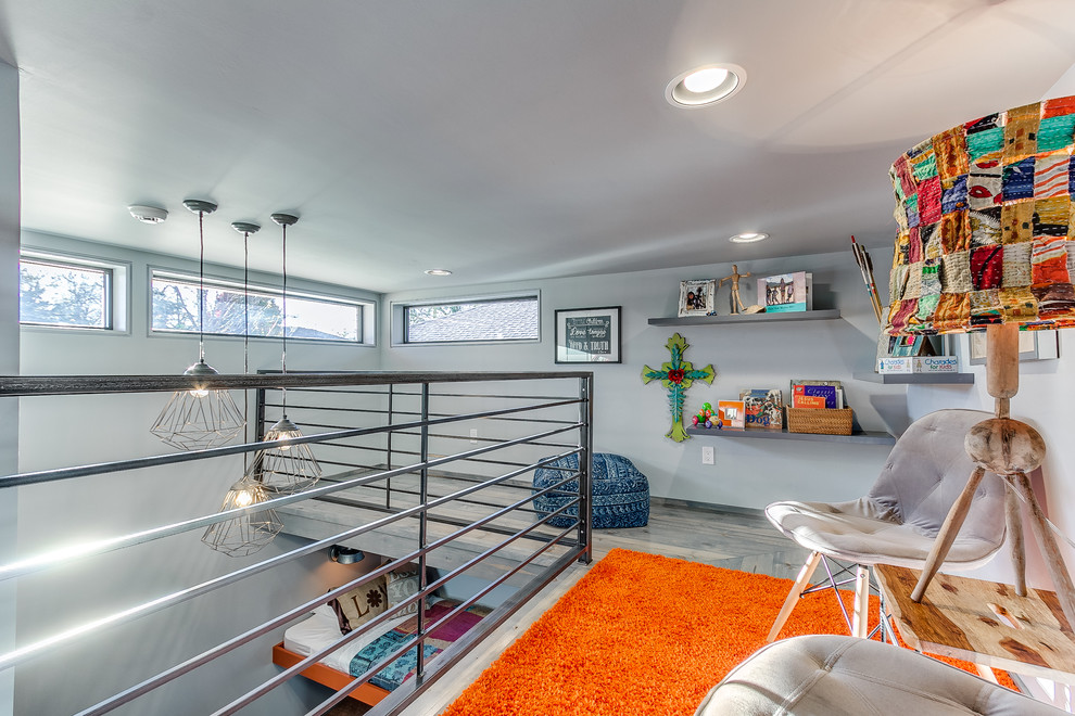 Ejemplo de dormitorio tipo loft minimalista con paredes grises y suelo de madera clara