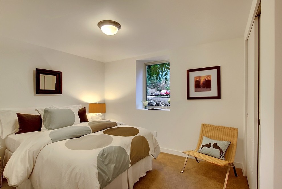 Foto på ett funkis sovrum, med heltäckningsmatta och vita väggar