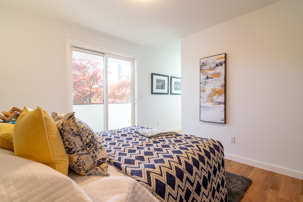 Foto di una camera da letto minimalista di medie dimensioni con pareti bianche, pavimento in legno massello medio e pavimento marrone