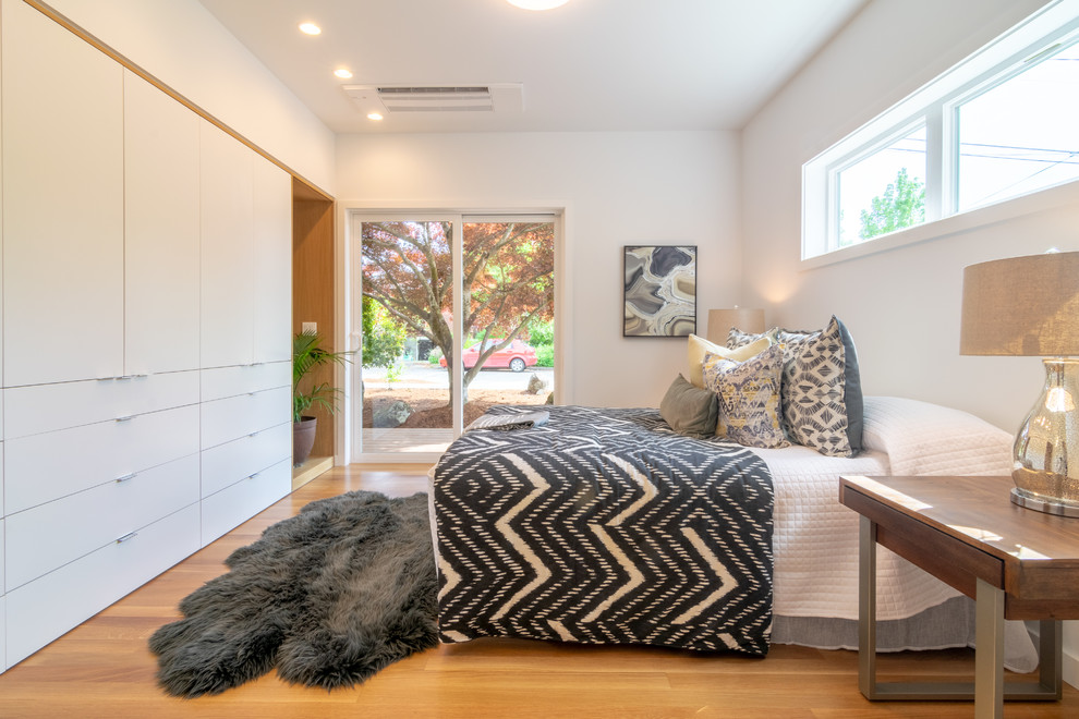 Mittelgroßes Modernes Hauptschlafzimmer ohne Kamin mit weißer Wandfarbe, braunem Holzboden und braunem Boden in Seattle