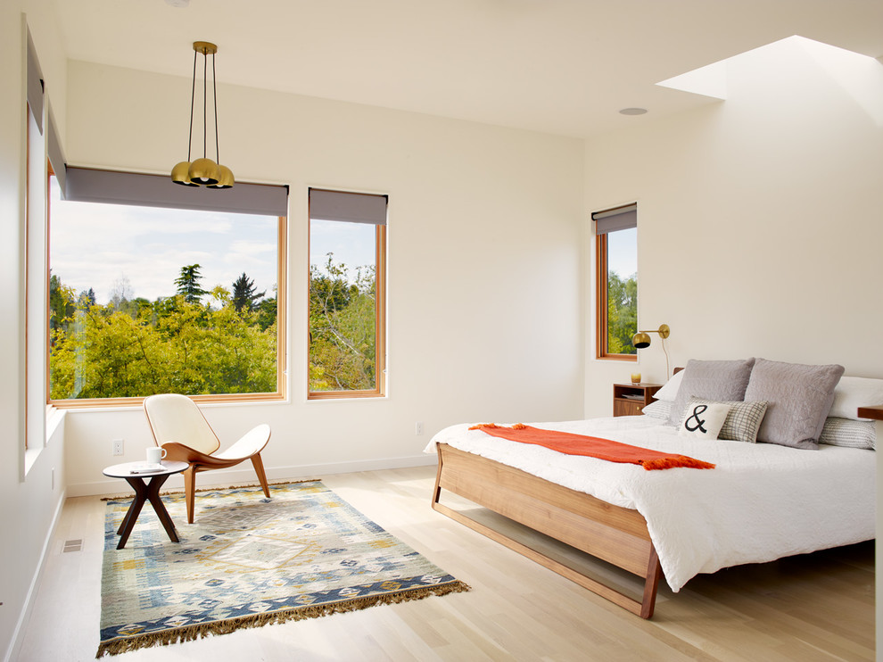 Cette image montre une chambre design avec un mur blanc, parquet clair et un sol beige.