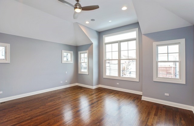 Modernes Gästezimmer ohne Kamin mit blauer Wandfarbe und braunem Holzboden in Chicago