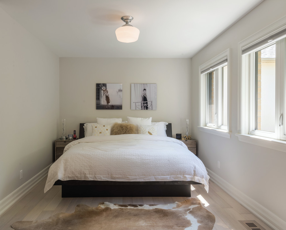 Foto de habitación de invitados actual de tamaño medio con paredes blancas y suelo de madera clara