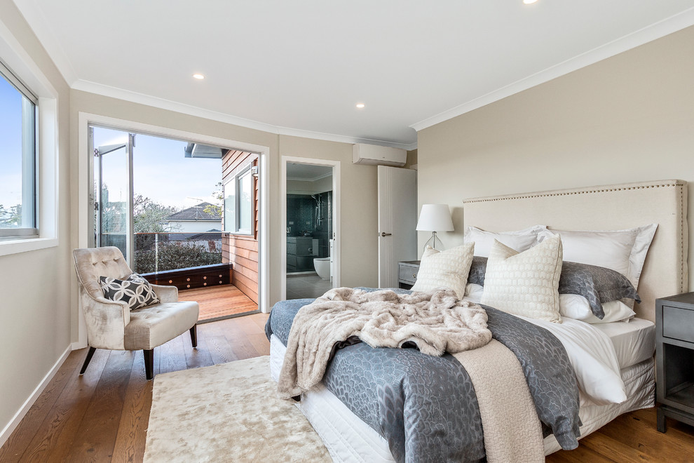 Inspiration for a large traditional master and grey and brown bedroom in Auckland with beige walls, medium hardwood flooring and brown floors.