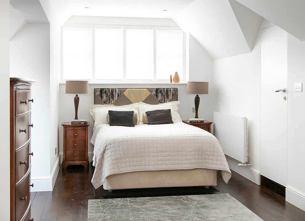 Modelo de habitación de invitados tradicional renovada pequeña sin chimenea con paredes blancas, suelo de madera oscura y techo inclinado