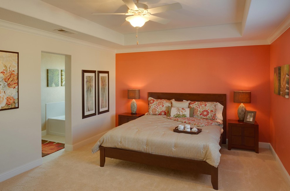 Inspiration for a large tropical master carpeted bedroom remodel in Sacramento with orange walls and no fireplace