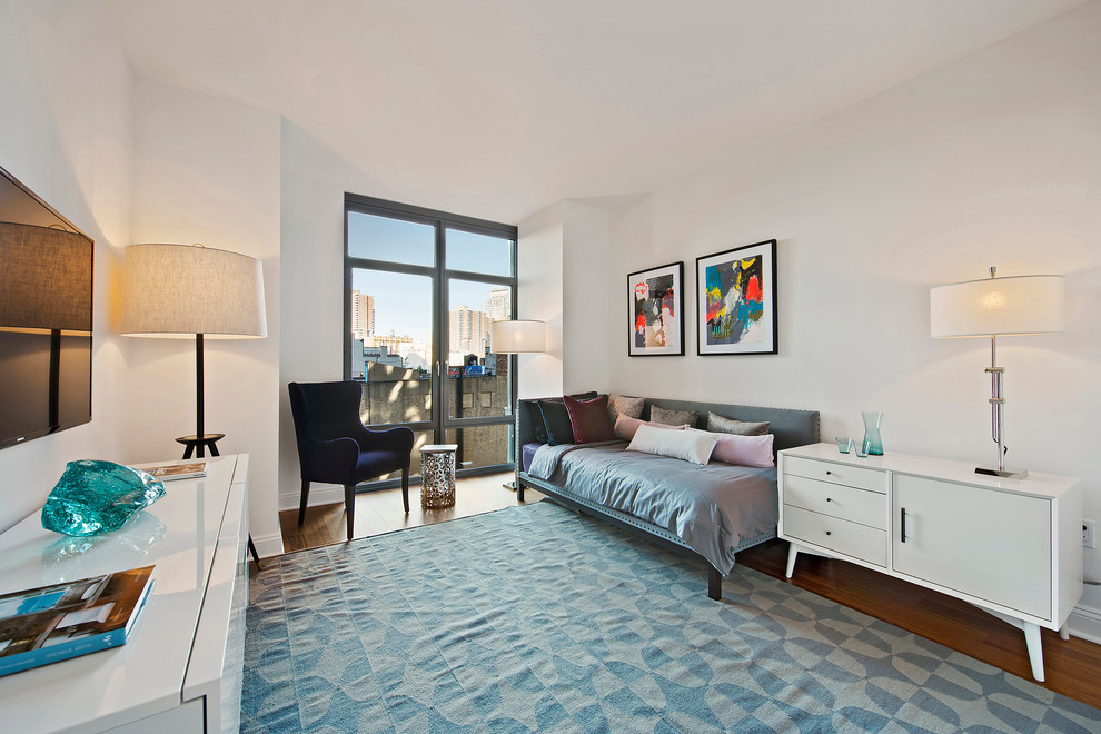 Immagine di una camera degli ospiti minimal con pareti bianche e pavimento in legno massello medio