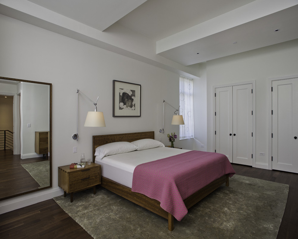 Modelo de dormitorio moderno con paredes blancas y suelo de madera oscura