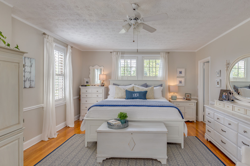 Imagen de dormitorio principal clásico con paredes beige y suelo de madera en tonos medios