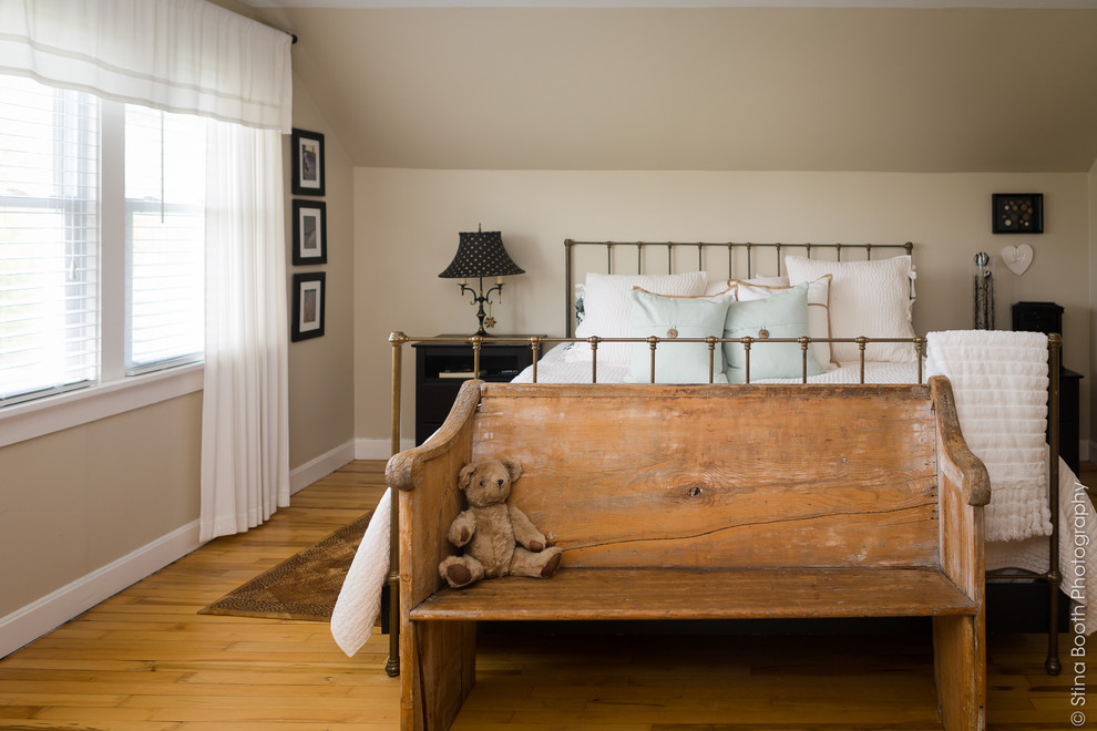 Bild på ett rustikt sovrum, med beige väggar och ljust trägolv
